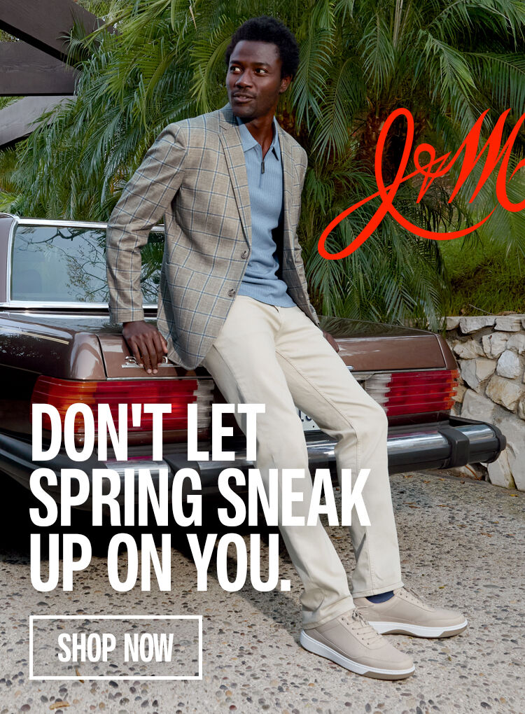 Man leaning on a vintage brown car wearing outfit styled by Johnston & Murphy. Don't Let Spring Sneak Up On You with a Shop Now button below. 